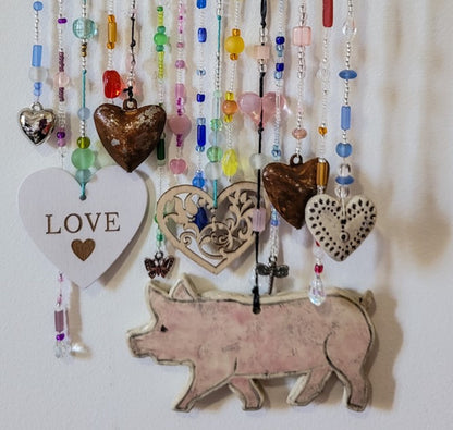 Handcrafted wall hanging with pig, hearts and beads